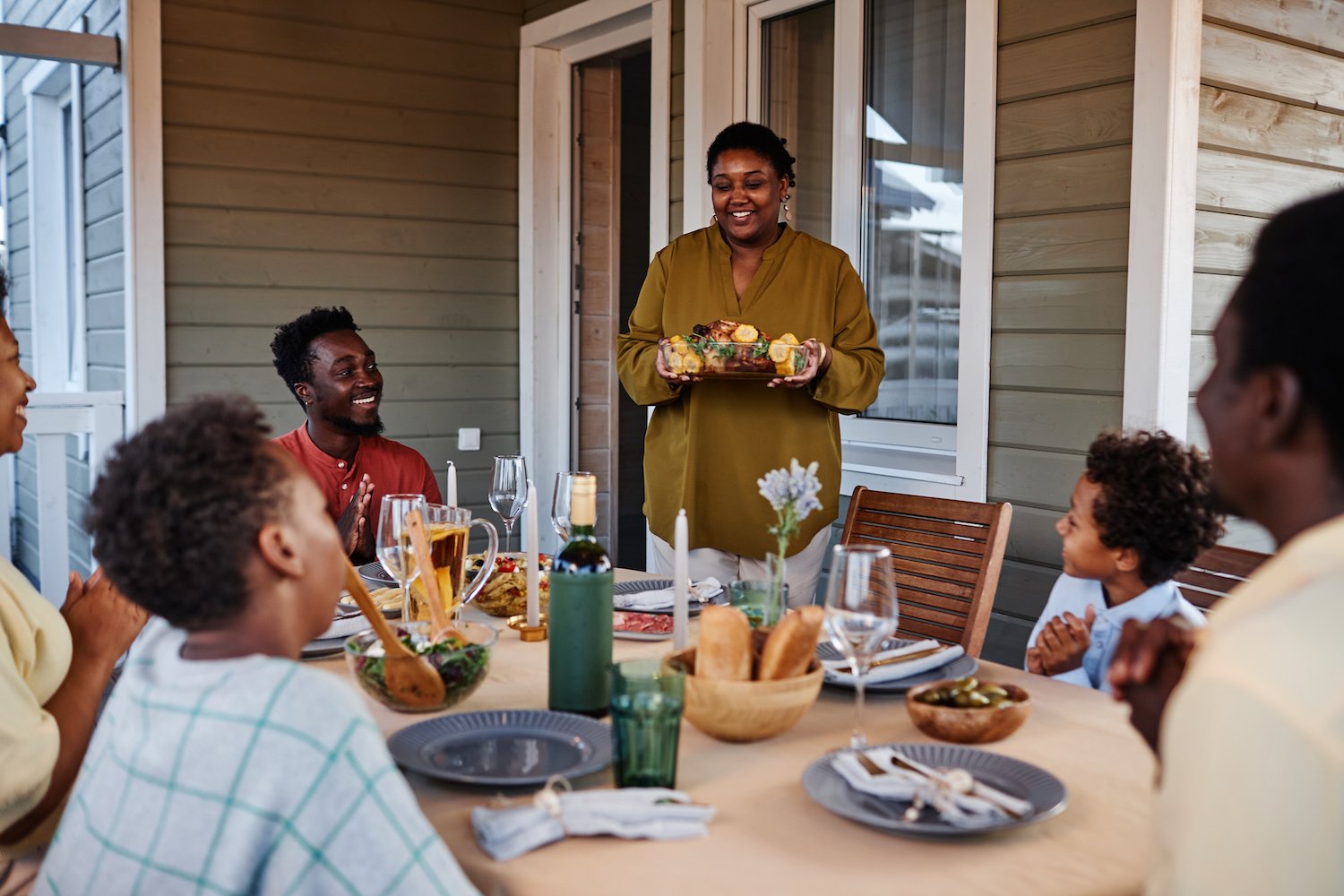 family sits down to dinner on porch